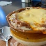 French Onion Soup - Delicious onions chopped up in a broth topped with house-made crouton, muenster, mozzarella