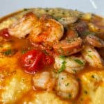 Shrimp & Grits - Sautéed shrimp, andouille sausage, blistered red tomatoes, smoky tomato cheese grits, scallions