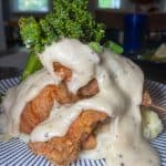 Country Style Fried Chicken - Buttermilk marinated chicken thigh, crispy panko crusted on homemade buttery mash potatoes, covered in a rich country gravy, & served with house vegetable