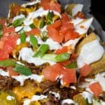 Smoked Pulled Pork Nachos - Fried tortillas topped with cheddar cheese, pickled jalapeños, sliced black olives, diced tomatoes, house-smoked pulled pork, & lime crema